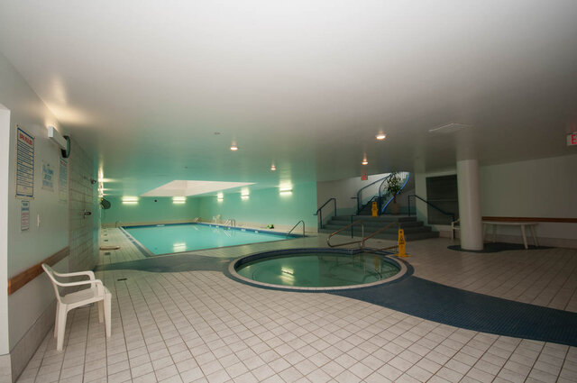 Spacious indoor pool area with tiled floors and stairs leading to a spa. - THA - 1199 Marinaside Cres, Vancouver Downtown