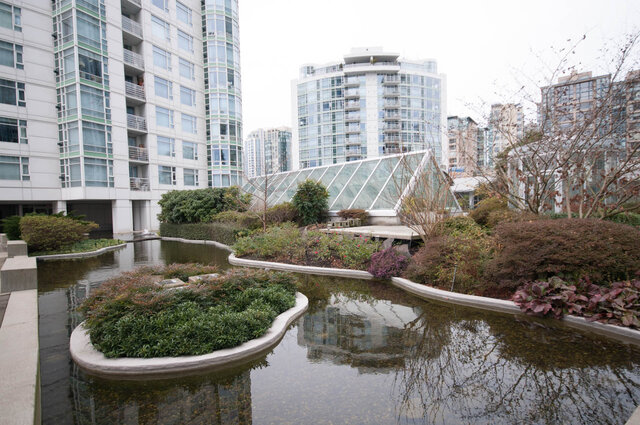 Spacious living room with modern furnishings and a serene water garden view. - THA - 1199 Marinaside Cres, Vancouver Downtown