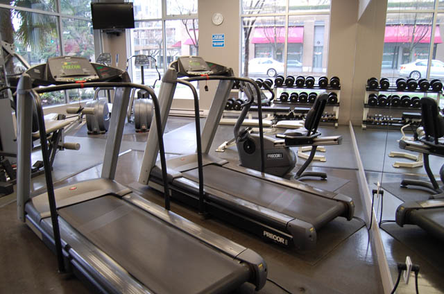Spacious fitness room with treadmills and dumbbells, overlooking city views. - 1705 - 989 Beatty St, Vancouver Downtown