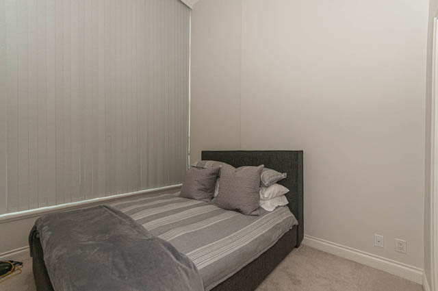 Furnished 1-bedroom with cozy bedding and neutral decor. - 105 - 199 Victory Ship Way, North Vancouver
