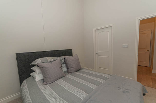 Furnished 1-bedroom condo with cozy bedding and wooden flooring. - 105 - 199 Victory Ship Way, North Vancouver