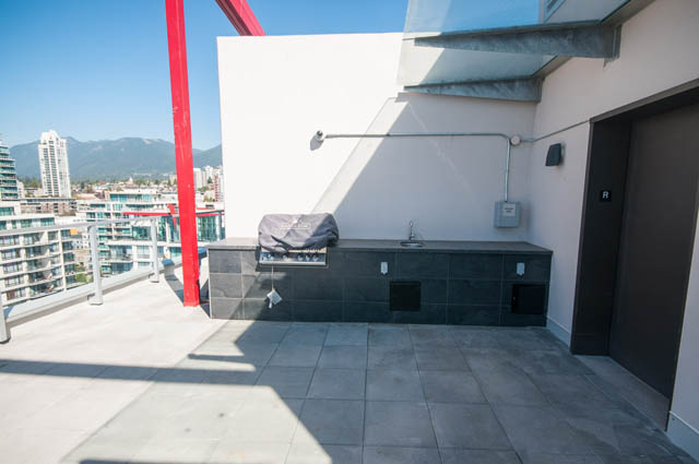 Bright rooftop patio with city view, modern design, and outdoor grill. - 105 - 199 Victory Ship Way, North Vancouver