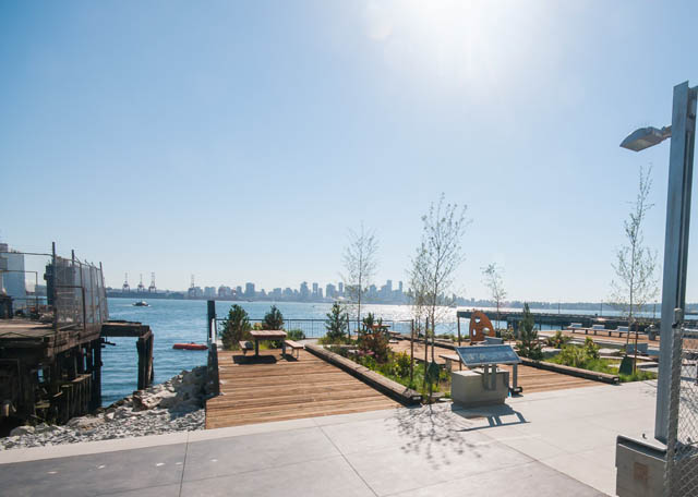 Bright living room with city view and waterfront access. - 105 - 199 Victory Ship Way, North Vancouver