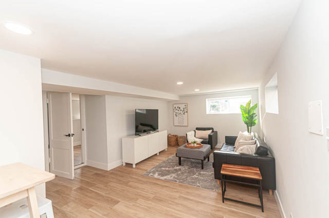 Bright living room with hardwood floors and modern furnishings. - Suite - 522 5th St E, North Vancouver
