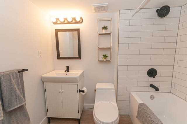 Bright bathroom with white subway tiles and modern fixtures. - Suite - 522 5th St E, North Vancouver