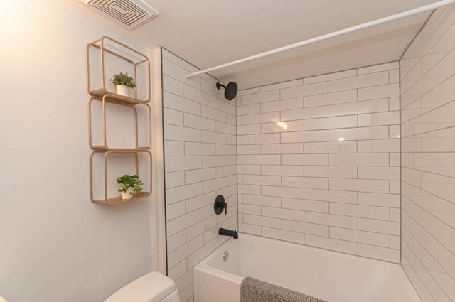 Furnished bathroom with white subway tiles and modern shower fixtures. - Suite - 522 5th St E, North Vancouver