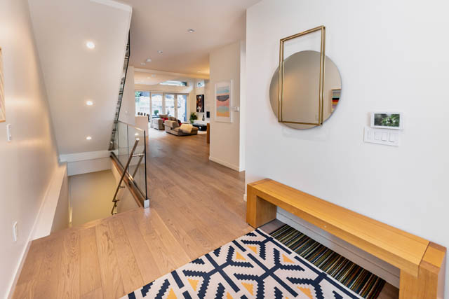 Staircase leading to a bright, open-concept living area with hardwood floors and a modern design. - Address WITHHELD, North Vancouver