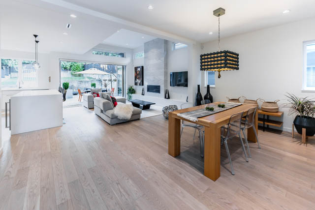 Open-concept living space with hardwood floors, modern furnishings, and a view of the backyard. - Address WITHHELD, North Vancouver
