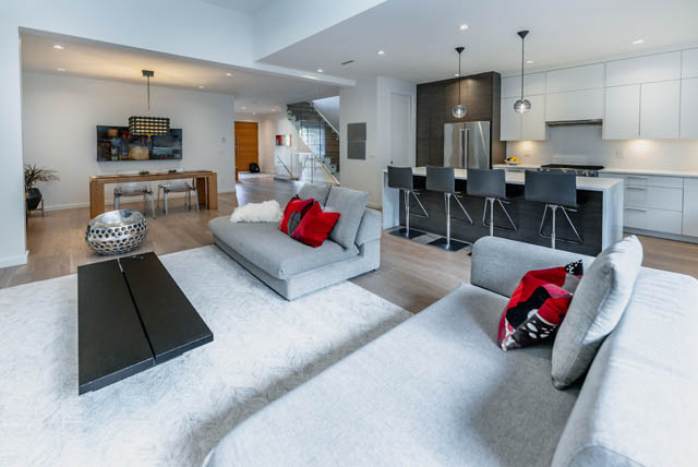 Bright living room with modern furniture, hardwood floors, and a kitchen in the background. - Address WITHHELD, North Vancouver