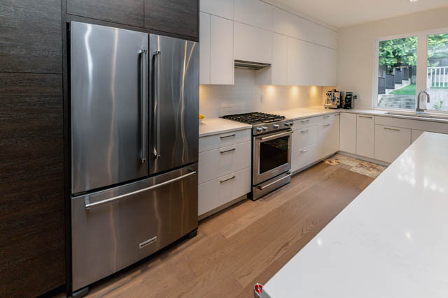 Bright kitchen with white countertops, stainless steel appliances, and hardwood floors. - Address WITHHELD, North Vancouver