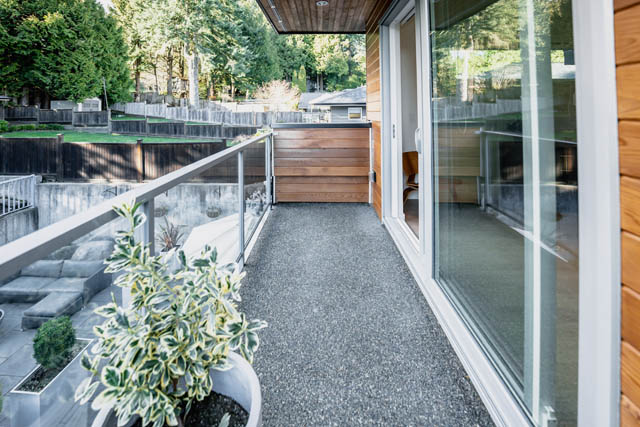 Bright living room with large windows, wooden accents, and a view of the forest. - Address WITHHELD, North Vancouver