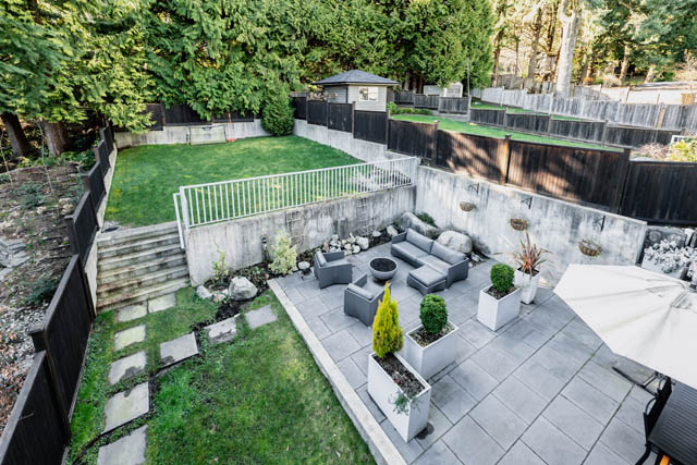 Furnished backyard with stone patio and greenery. - Address WITHHELD, North Vancouver
