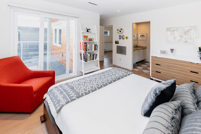 Bright living room with red sofa, hardwood floors, and city view. - Address WITHHELD, North Vancouver