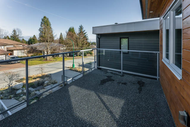 Furnished balcony with modern railings and gravel ground, overlooking a quiet street. - Address WITHHELD, North Vancouver