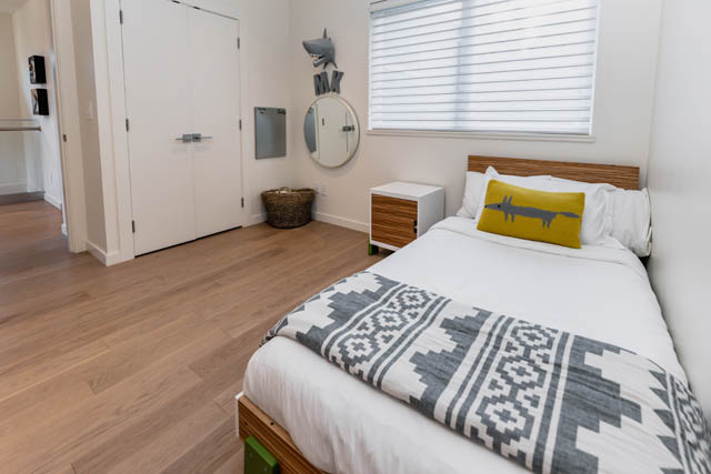 Bright bedroom with hardwood floors, white walls, and a shark-themed decor. - Address WITHHELD, North Vancouver