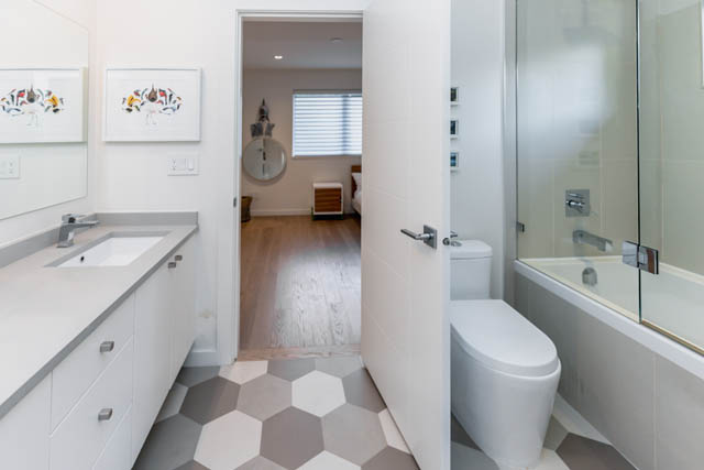 Modern bathroom with hexagonal tile flooring and sleek white fixtures. - Address WITHHELD, North Vancouver