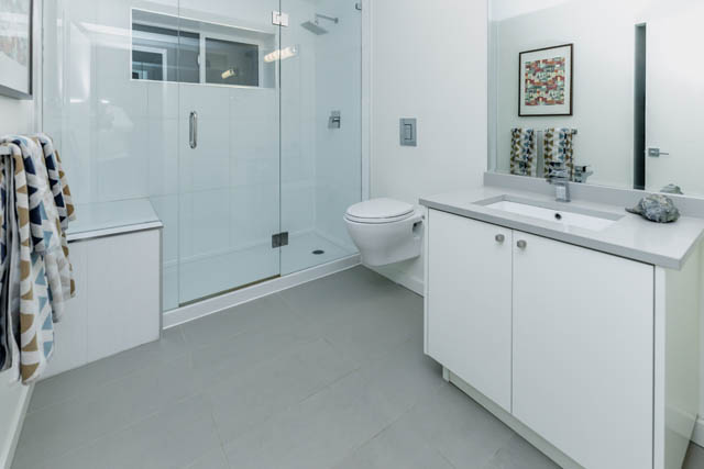 Modern bathroom with white cabinetry, glass shower, and sleek sink. - Address WITHHELD, North Vancouver
