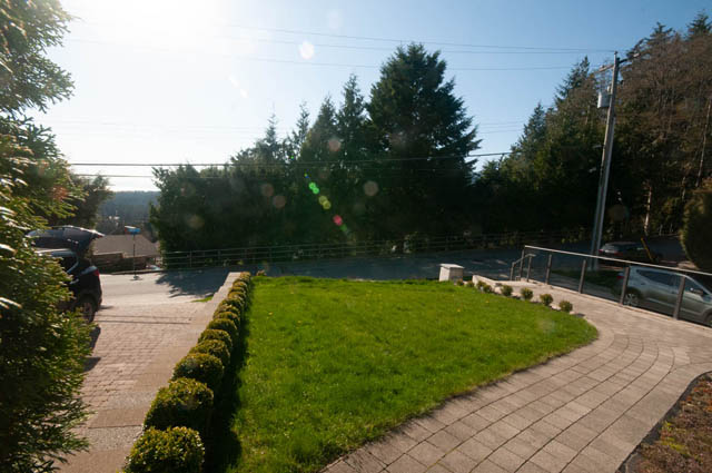 Bright outdoor patio with lush greenery and paved walkway. - Suite - 4796 Skyline Dr, North Vancouver