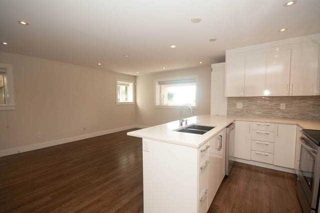 Bright kitchen with white cabinets, hardwood floors, and a city view. - Suite - 4796 Skyline Dr, North Vancouver