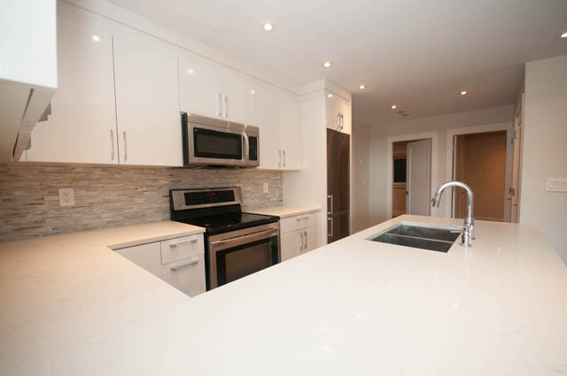 Bright kitchen with white countertops and modern appliances, spacious and well-lit. - Suite - 4796 Skyline Dr, North Vancouver