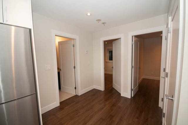 Bright kitchen with stainless steel appliances and hardwood floors. - Suite - 4796 Skyline Dr, North Vancouver