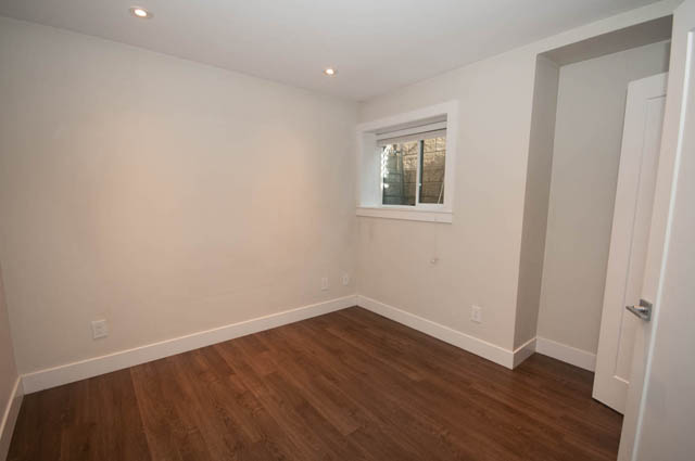 Bright living room with hardwood floors and a small window. - Suite - 4796 Skyline Dr, North Vancouver
