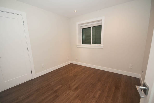 Bright bedroom with hardwood floors and a window. - Suite - 4796 Skyline Dr, North Vancouver