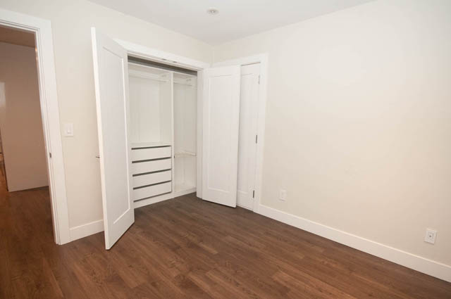 Bright bedroom with hardwood floors and white closet doors. - Suite - 4796 Skyline Dr, North Vancouver