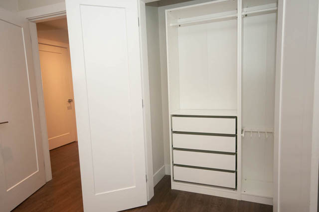 Bright bedroom with white closet and hardwood floors. - Suite - 4796 Skyline Dr, North Vancouver