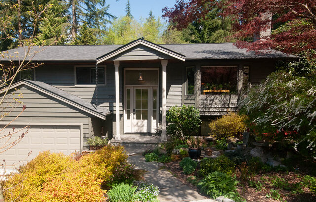 Spacious living room with a cozy fireplace and large windows. - Upper - 2352 Riverbank Pl, North Vancouver