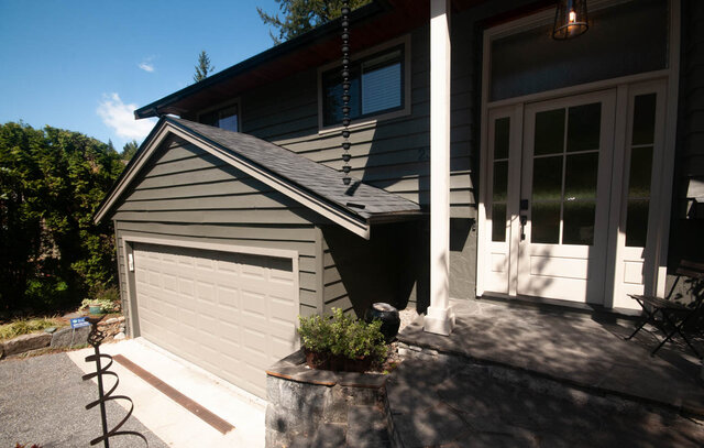 Cozy 3-bedroom shared house with a modern gray exterior, white French doors, and a stone patio. - Upper - 2352 Riverbank Pl, North Vancouver