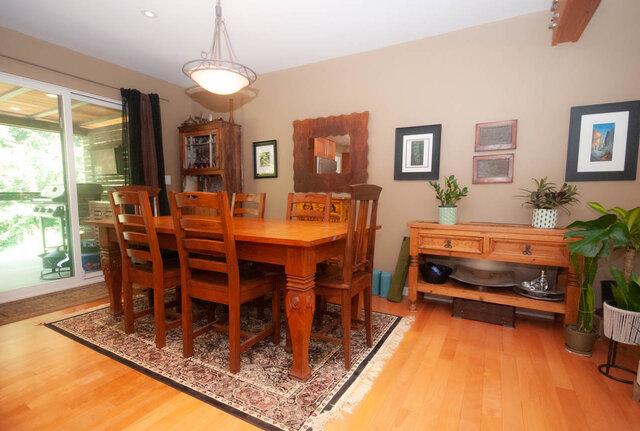 Spacious dining area with wooden furniture, hardwood floors, and a view of the backyard. - Upper - 2352 Riverbank Pl, North Vancouver