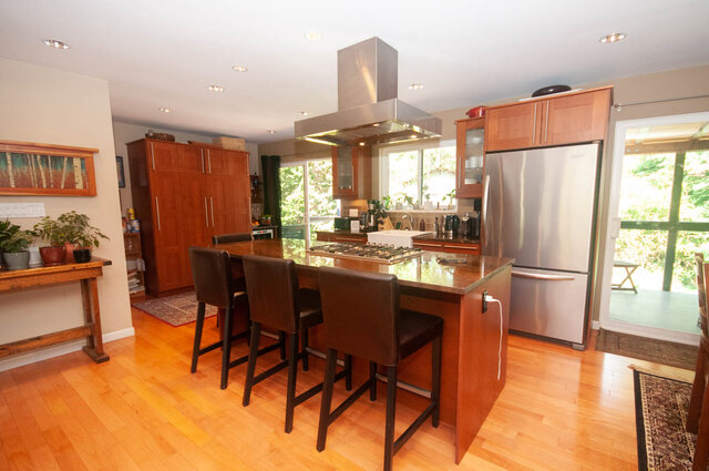 Bright kitchen with wooden cabinets, stainless steel appliances, and hardwood floors. - Upper - 2352 Riverbank Pl, North Vancouver
