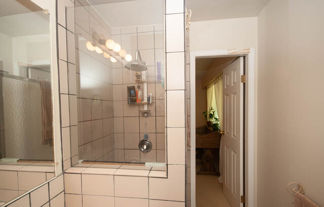Spacious bathroom with tiled shower and large mirror. - Upper - 2352 Riverbank Pl, North Vancouver