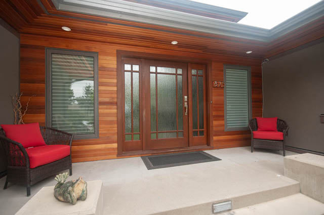 Furnished patio with wooden walls, red cushions, and modern lighting. - Upper - 876 48th Ave, Vancouver West Side