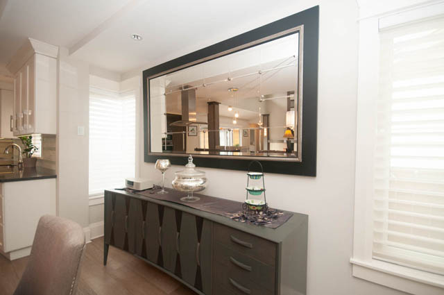 Furnished living room with large mirror and hardwood floors. - Upper - 876 48th Ave, Vancouver West Side