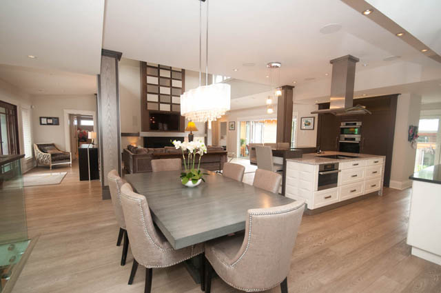 Open-concept living space with modern decor, hardwood floors, and a large kitchen island. - Upper - 876 48th Ave, Vancouver West Side