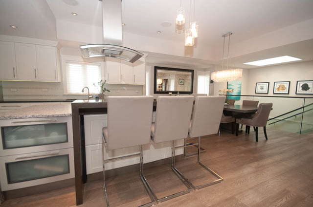 Bright kitchen with white cabinets, granite countertops, and hardwood floors. - Upper - 876 48th Ave, Vancouver West Side