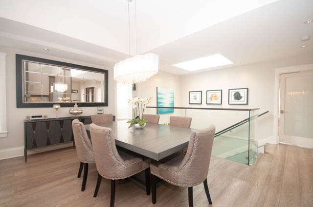 Furnished dining area with modern chandelier, hardwood floors, and large mirror. - Upper - 876 48th Ave, Vancouver West Side