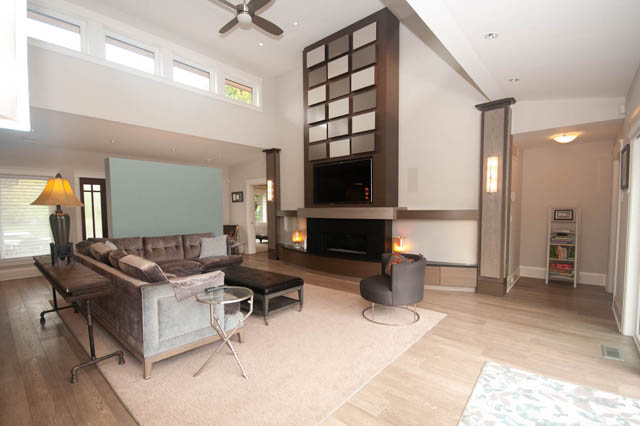 Spacious living room with hardwood floors, modern fireplace, and large windows. - Upper - 876 48th Ave, Vancouver West Side