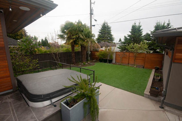 Furnished patio with grass, palm trees, and wooden fencing. - Upper - 876 48th Ave, Vancouver West Side