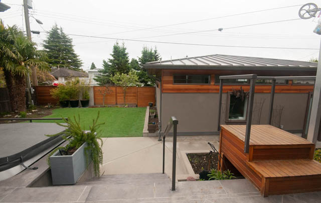 Spacious patio with wooden deck and modern house in the background. - Upper - 876 48th Ave, Vancouver West Side