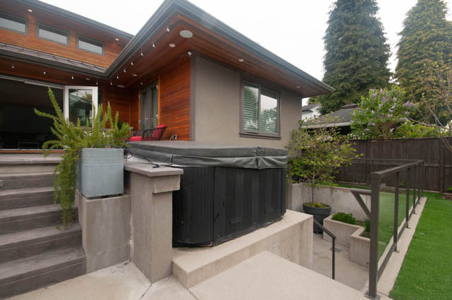 Furnished living room with modern wood accents and outdoor hot tub. - Upper - 876 48th Ave, Vancouver West Side