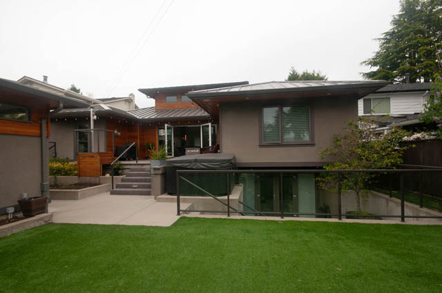 Spacious living room with modern design, large windows, and outdoor access. - Upper - 876 48th Ave, Vancouver West Side