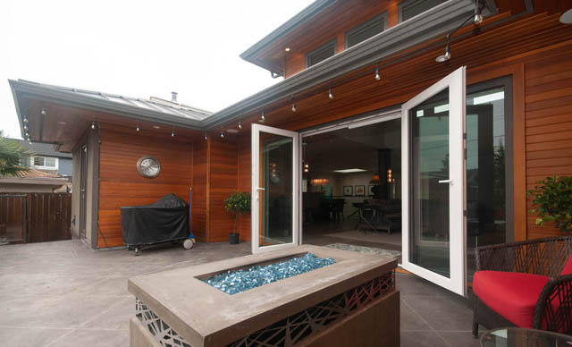 Furnished patio with modern wood paneling, glass table, and outdoor seating. - Upper - 876 48th Ave, Vancouver West Side