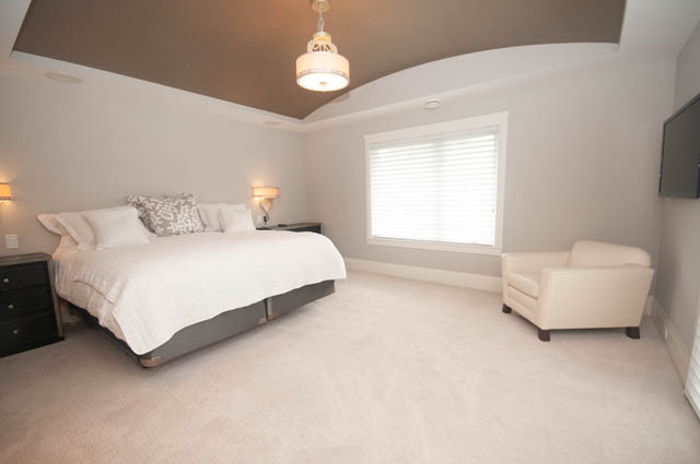 Spacious bedroom with large window, modern lighting, and neutral decor. - Upper - 876 48th Ave, Vancouver West Side