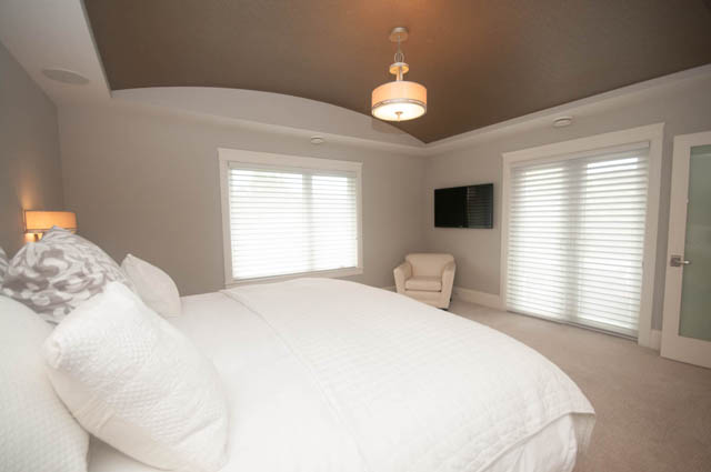Spacious bedroom with white bedding and large windows, perfect for relaxation. - Upper - 876 48th Ave, Vancouver West Side