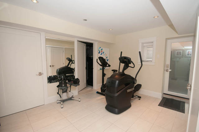 Fitness room with exercise bikes and mirrors, light-colored walls and flooring. - Upper - 876 48th Ave, Vancouver West Side