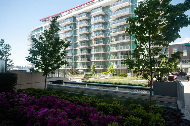 Furnished living room with modern furnishings and city view. - 404 - 185 Victory Ship Way, North Vancouver