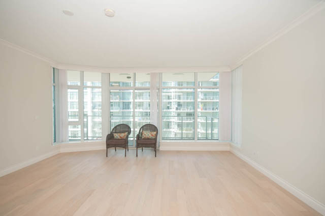 Bright living room with hardwood floors and city view. - 404 - 185 Victory Ship Way, North Vancouver
